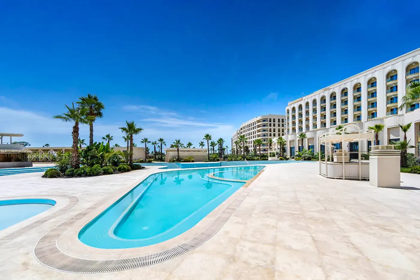АК Mantera Seaview Residence в Сириусе: бассейны и арочный корпус у моря